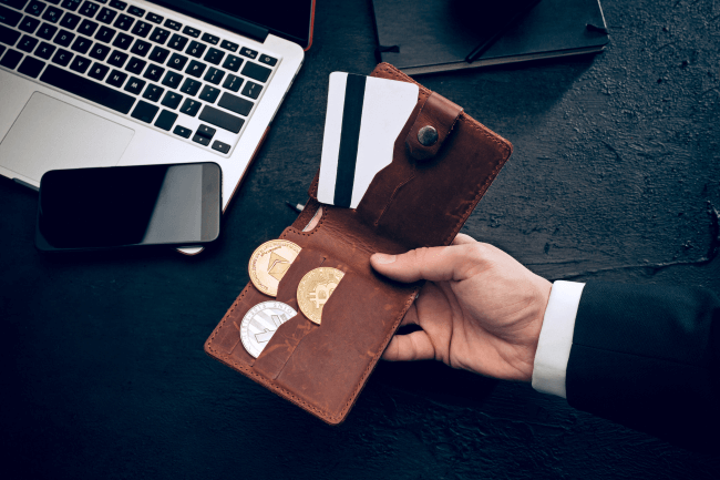 Kädessä lompakko salauksella ja luottokortilla