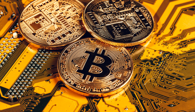 Gylden bitcoin og computerchip i baggrunden