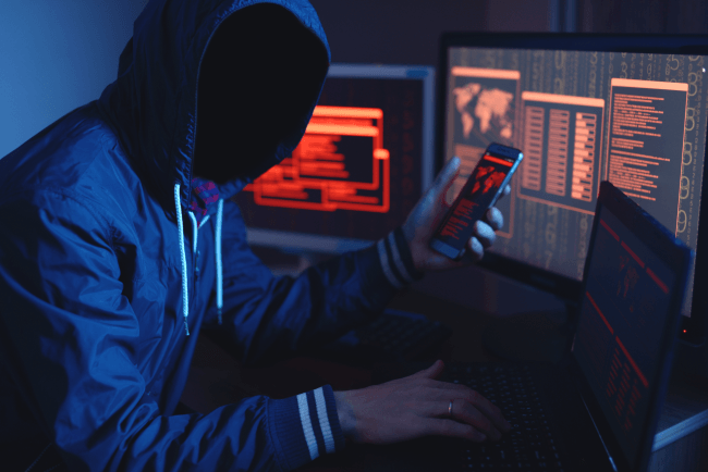 En anonym hacker uden ansigt, der skriver koden, forsøger at stjæle adgang